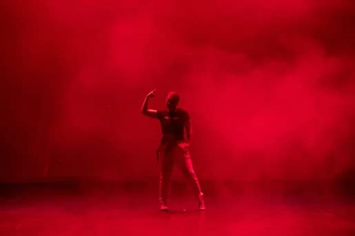 Hip hop dancer on a stage lit red with haze